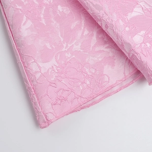 Detail of pink jacquard fabric with 3D floral texture and high-density stitching edges