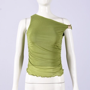 Détail du haut vert asymétrique en tulle avec fronces et boucle dorée à l'épaule