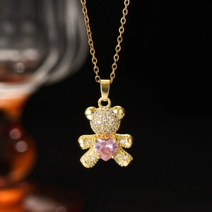 Detail of bear pendant with white zircons, pink heart gemstone and gold chain