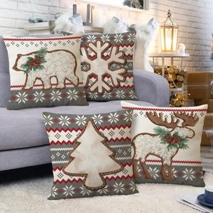 Set of 4 Christmas linen pillow covers with bear and elk prints on a cozy sofa