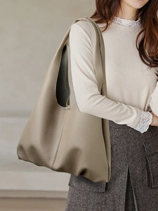 Minimalist beige soft leather tote bag for women showing spacious hobo style on shoulder