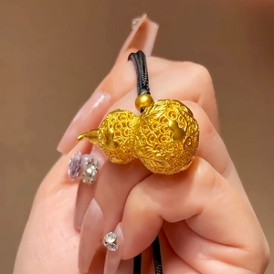 Close-up of 24k gold-plated hollow gourd pendant with detailed floral patterns