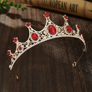 Detailed close-up of golden crown with red oval gemstones and sparkling rhinestones