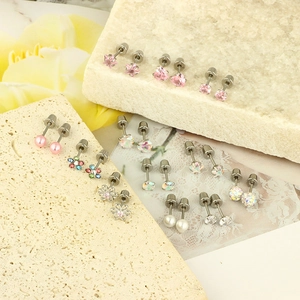 Detail showing 12 pairs of varied stud earrings with heart and star shapes on stones