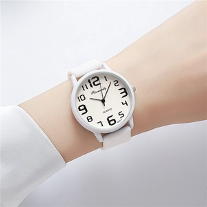 Wrist view of a white silicone sports watch with clear black Arabic numerals on dial
