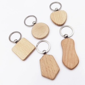 DIY wooden keychains in various shapes including round and heart with metal rings on white