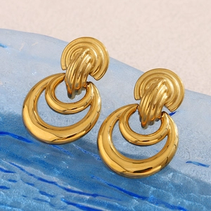 Detailed macro view of 18K gold plated multi-layered stacked hoop earrings on blue glass