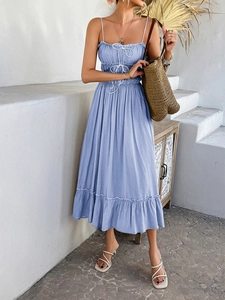 Detail of blue A-line dress with pleated bust, spaghetti straps, and ruffled hem in sunlight