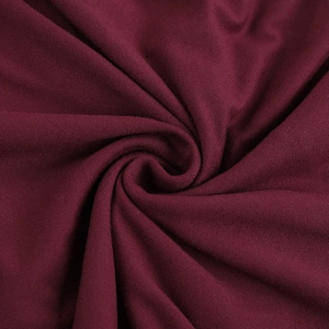 Close-up of wine red knitted fabric with soft texture and elegant ruched details