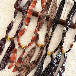 Detailed view of bohemian fabric necklaces with floral patterns and wooden beads