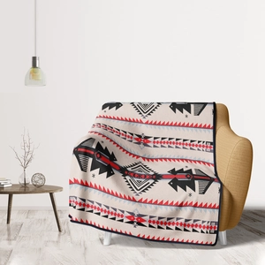 Detail of soft flannel throw blanket with tribal geometric patterns on a yellow sofa