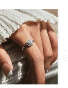 Close-up of a square moissanite silver ring worn with a white knitted sweater background