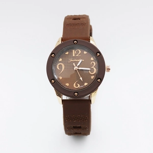 Detail view of vintage watch with brown leather-textured strap and gold metal casing