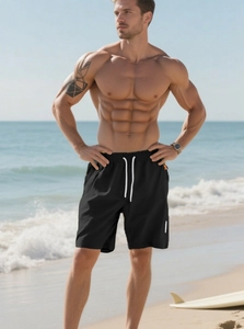 Detail of men's quick-dry black swim shorts with white drawstring in a beach setting