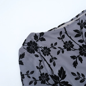 Detail of grey mesh fabric with black flocked floral patterns on the shoulder and neckline