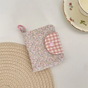 Close-up of floral fabric coin purse with pink checkered flap and handy carabiner clip