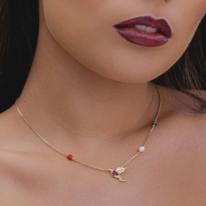 Detail of S925 silver hummingbird pendant necklace with ruby gemstone on model neck