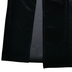 Détail de la fente latérale et du tissu en velours luxueux sur cette robe noire élégante