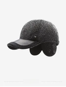 Detail of grey faux fur winter baseball cap with black leather brim and ear flaps
