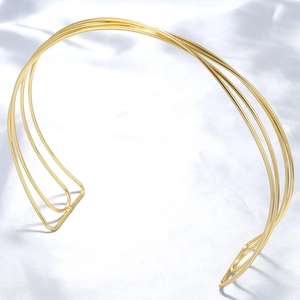 Detail of minimalist golden metal collar necklace with hollow geometric striped lines