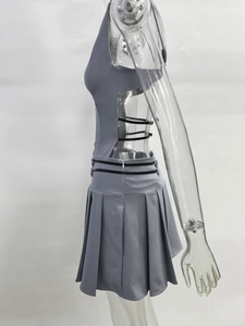 Détail du haut dos nu gris et de la jupe plissée avec sangles à boucles métalliques