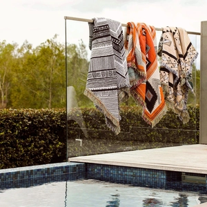 Detailed view of woven Bohemian blankets with ethnic geometric patterns and fringe tassels