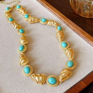 Vue détaillée du collier vintage avec pierres turquoises et maillons dorés à texture fine