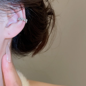 Close-up of silver vine ear cuff with zircon crystals worn on woman's cartilage