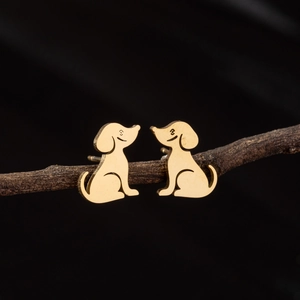Minimalist gold stainless steel puppy dog stud earrings displayed on a dark wooden branch