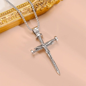 Macro shot of vintage silver cross pendant with Jesus figure and screw nail design