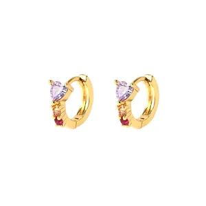 Détail de boucles d'oreilles cœur dorées avec pierre zircon violette et cristaux colorés