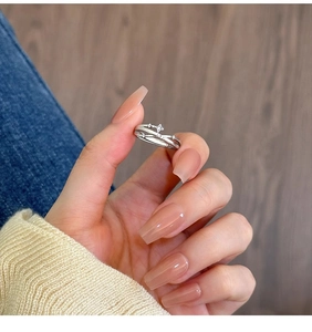 Detailed view of silver multi-layered star ring with cubic zirconia on a female finger