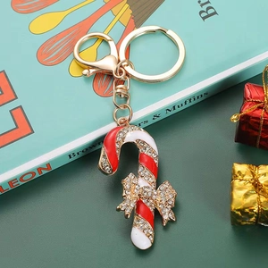 Golden Christmas candy cane keychain with sparkling rhinestones and festive red bow charm