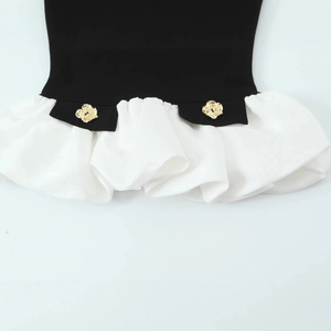 Black and white patchwork top with gold rose buttons and elegant ruffled hem detail