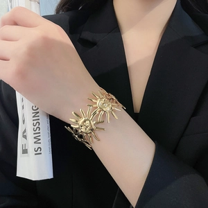 Detailansicht eines luxuriösen goldenen Armreifs mit Sonnengesicht am Handgelenk