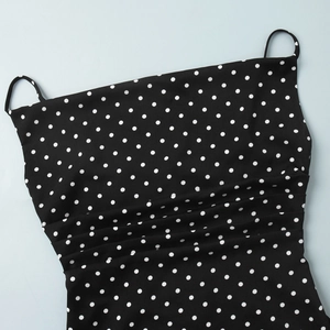 Detailed view of the black and white polka dot dress featuring ruched chest design