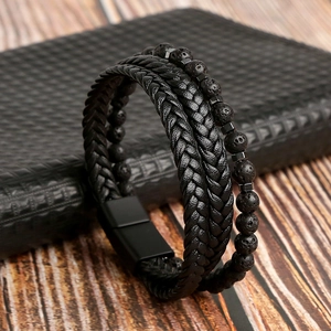 Dettaglio del bracciale in pelle intrecciata nera con perle di lava e chiusura magnetica