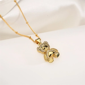 Macro shot of gold-plated bear pendant necklace with sparkling cubic zirconia on white silk