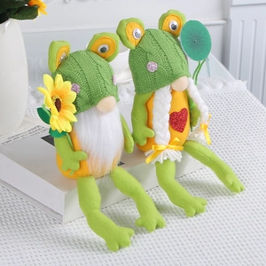 Coppia di gnomi di peluche a forma di rana con cappelli a maglia e girasoli su tavolo