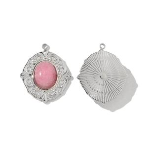 Detail of vintage pink stone heart pendant with intricate silver lace filigree bezel
