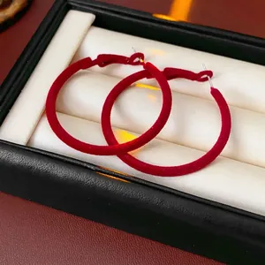 Deep red flocked hollow hoop earrings with silver pins in luxury jewelry box display