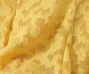 Detailansicht aus der Nähe von gelbem Jacquard-Stoff mit feinen 3D-Blattmustern