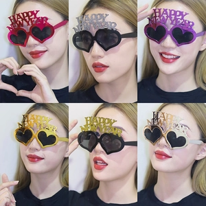 Macro detail of Happy New Year heart-shaped party glasses in six glittery colors