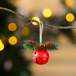 Détail d'une cloche en métal rouge avec pommes de pin et baies pour déco de Noël