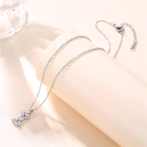 Macro shot of silver bow pendant with cubic zirconia on a titanium steel necklace