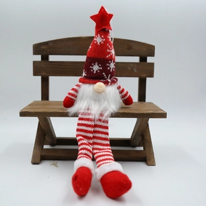Détail d'un gnome de Noël avec bonnet tricoté à flocons et longues jambes rayées