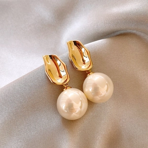 Detailansicht französischer Vintage-Ohrringe mit Goldperlen auf elegantem Seidenstoff