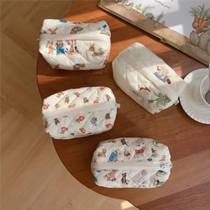 Detailed macro view of cute quilted cotton cosmetic bags with bear and floral patterns