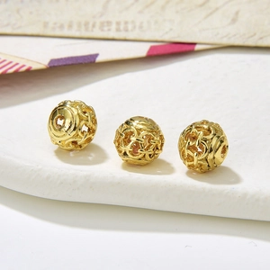Macro shot of three vintage hollowed-out golden beads for DIY jewelry making