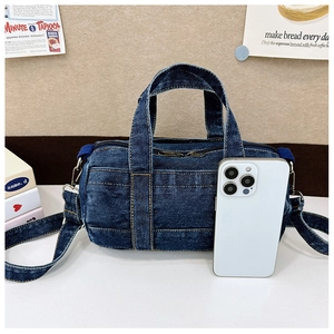 Close-up of blue denim kids crossbody bag with yellow stitching and white phone size reference